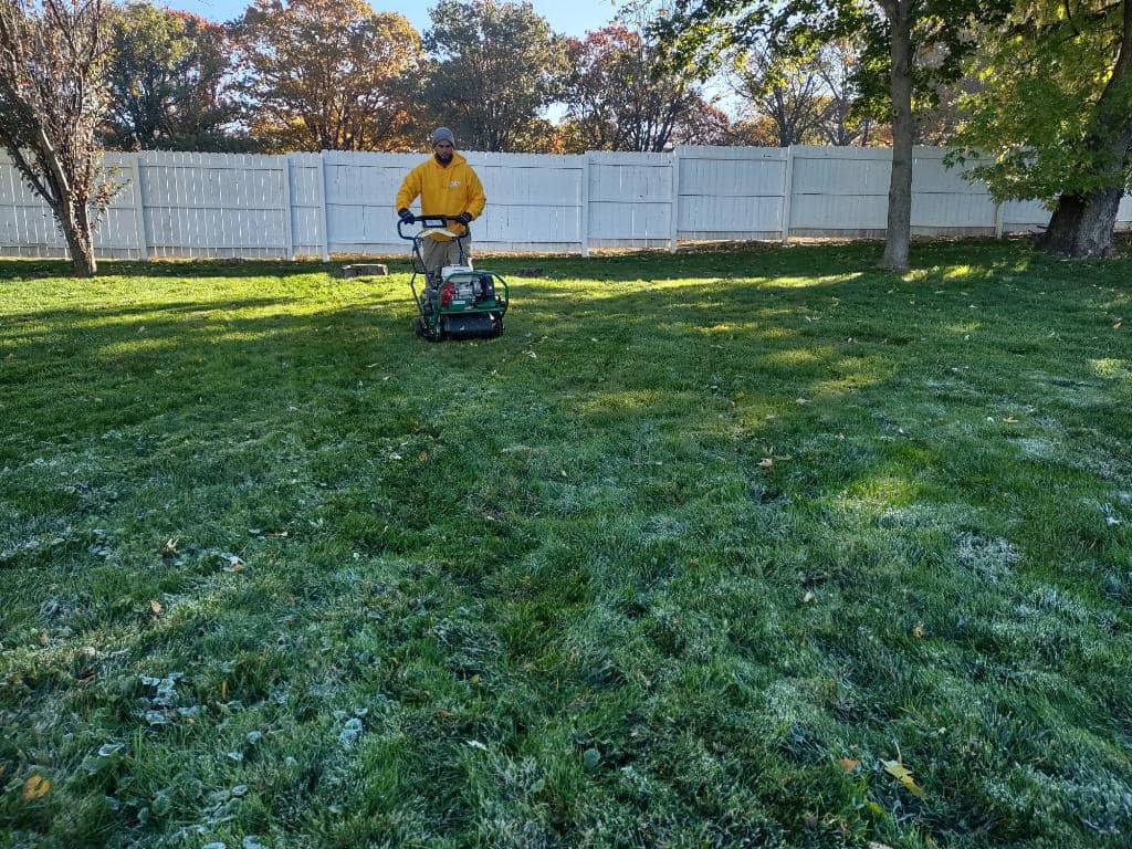 man in a yellow jacket lawn mowing